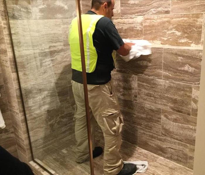 SERVPRO Technician Cleaning Shower